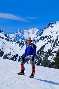 Man climber on snow covered mounain top. Mount Shuksan, North Cascades National Park, Washington state, USA. 