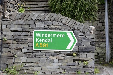 A UK road sign, showing direction to Windermere and Kendal