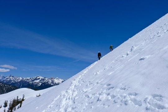 Friends climbers on snow covered streep mountain slope. Mount Baker wilderness, North Cascades National Park, Washington, USA. 