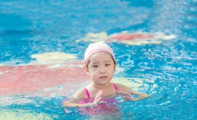 Fototapeta na wymiar Asian girl is playing in the pool