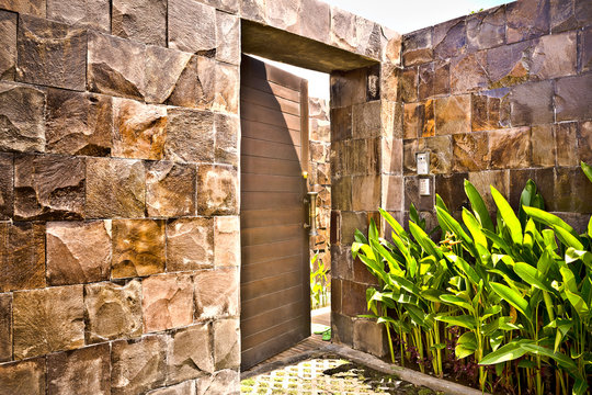 Stone wall entrance to a modern mansion