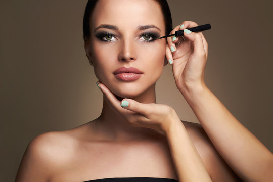Makeup artist applies eye shadow. Beautiful woman face. beauty girl with Perfect make-up