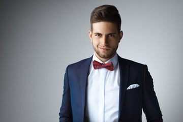 Stylish young man in suit and tie. Business style. Fashionable image. Office worker. Sexy man standing and looking at the camera. Ceremonial clothes. Secular person. Hipster look