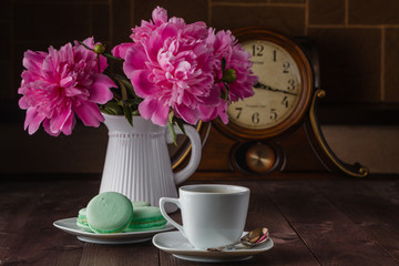 cup of coffee and flowers (peonies) on daark wooden table