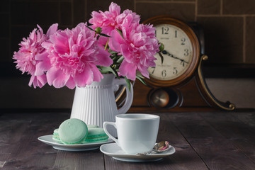 cup of coffee and flowers (peonies) on daark wooden table