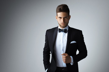 Stylish young man in suit and tie. Business style. Fashionable image. Office worker. Sexy man standing and looking at the camera. Ceremonial clothes. Secular person. Hipster look