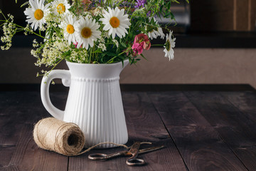 arrangement wildflowers in vase on wooden table