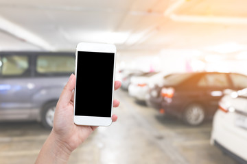 Hand with Smart phone with blank screen at parking area