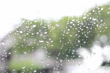 A very rare rainy day in Bangkok, Thailand with van and people as seen through car windows with rain drops visible on the window.