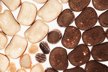 Slices of black rye bread and white bread on a white background. Food background. Pattern.