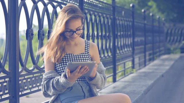 Girl using a digital tablet outdoors.