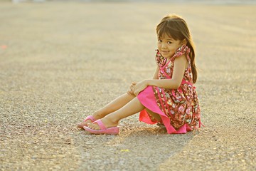 Cute little girl sitting alone at the park .