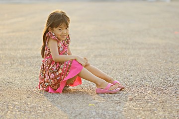 Cute little girl sitting alone at the park .