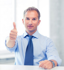smiling businessman showing thumbs up