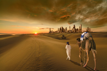 A man with a camel walking in the middle of the desert towards the kuwait city 