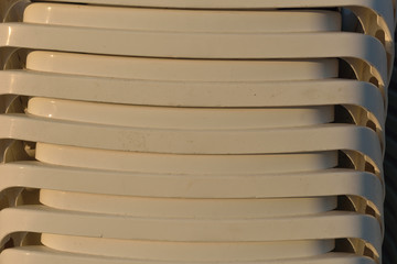 Close up of sunbeds on the beach stacked, ready to be put on the