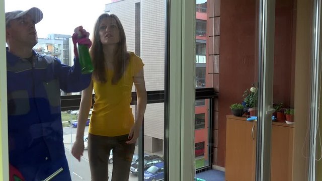 finicky young client woman give instructions for windows cleaner man.