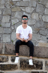 Naklejka premium Handsome young man with mobile phone on the street
