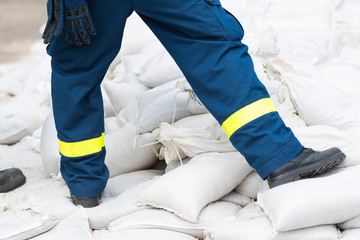 Helfer transportiert Sandsäcke