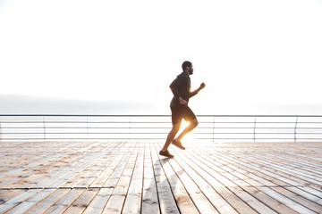 Concentrated man running on wooden terrace