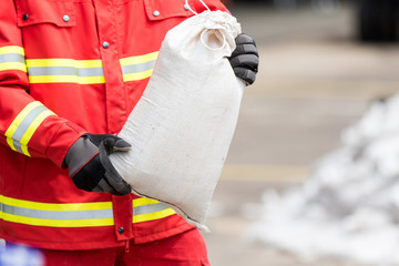 Helfer transportiert Sandsäcke