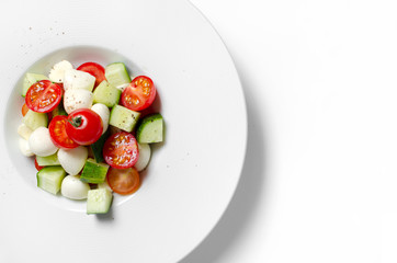 Vegetable salad with mozzarella on a white background