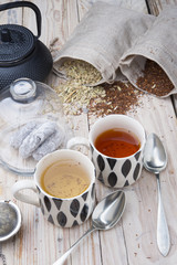 two cups 1 black tea rooibos and other fennel with teapot in the