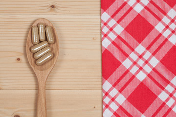Herbal capsules on wooden spoon. herb for healthy