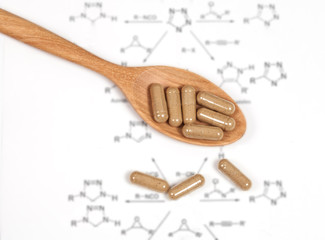 Capsules of herbs on spoon