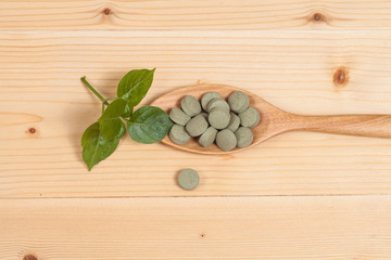 Herbal pill on wooden spoon. herb for healthy living.