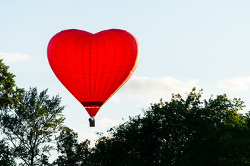 Hot air balloon - red heart over the trees