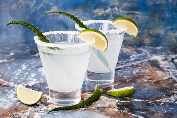 Aloe vera margarita cocktail with salty rim on marble table .