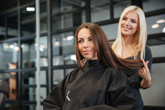 Hairdresser giving a new haircut to female customer at parlor