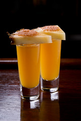 Fruity alcohol shots with slices of pineapple.