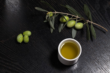 Branch of olive tree with green olive berries and cap of fresh o