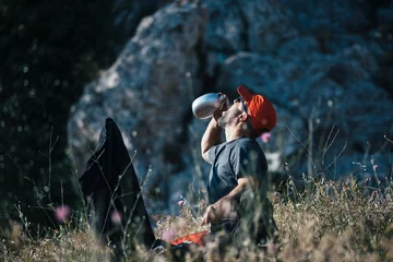 Crédence de cuisine en verre imprimé Alpinisme Backpacker drinking water from flask