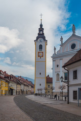 Fototapeta na wymiar Kamnik, Slovenia - January 25, 2016. Church of the Immaculate Conception with its Tower on the main town street called Sutna.
