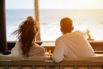 couple watching the sea from the terrace of  their apartment