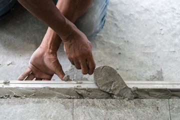 Man mason building a screed coat cement on floor
