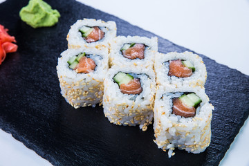 Sushi Set nigiri and sushi rolls on black stone slate. Restaurant food concept.