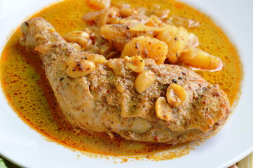 chicken leg in spicy and sweet yellow curry on dish