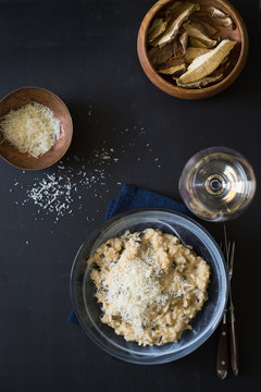 Dried porcini mushrooms risotto sprinkled with grated parmesan cheese. Selective focus.