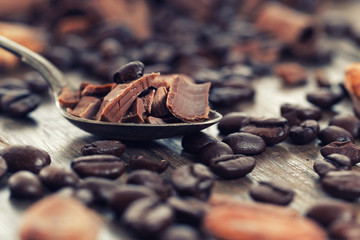 Chocolate pieces with cocoa and coffee beans on a wooden table