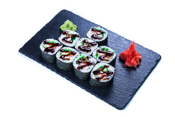 Sushi Set nigiri and sushi rolls on black stone slate. Restaurant food concept.