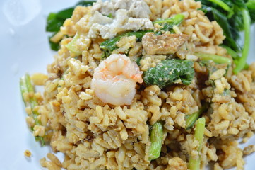 fried egg rice with pork and Chinese kale in black soy sauce topping shrimp on plate