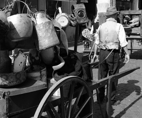 Elder street vendor with a cart full of pots