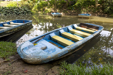 Obraz premium Blue Boat in lake surrounded by nature