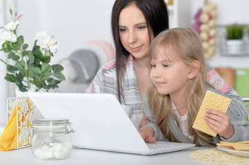 mother and daughter using laptop