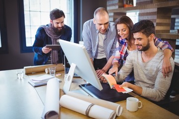 Creative coworkers discussing over document