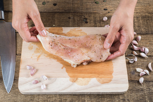 Food series : Closeup of woman hand marinating raw chicken breast with pepper